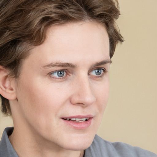 Joyful white young-adult male with short  brown hair and blue eyes