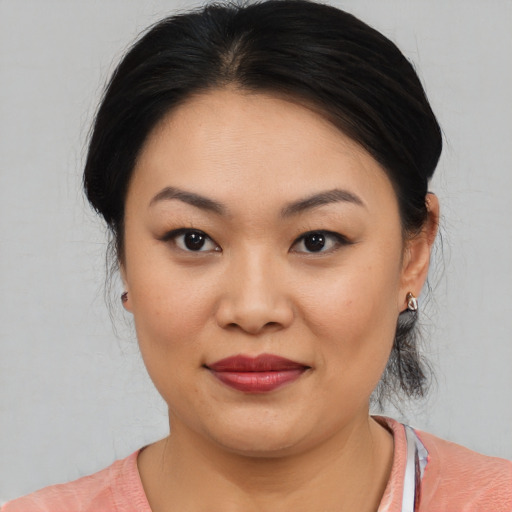 Joyful asian young-adult female with medium  black hair and brown eyes