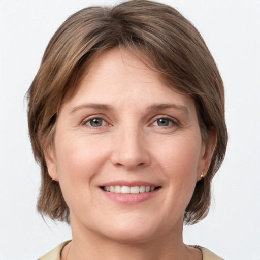 Joyful white young-adult female with medium  brown hair and grey eyes