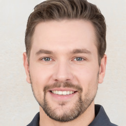 Joyful white young-adult male with short  brown hair and grey eyes