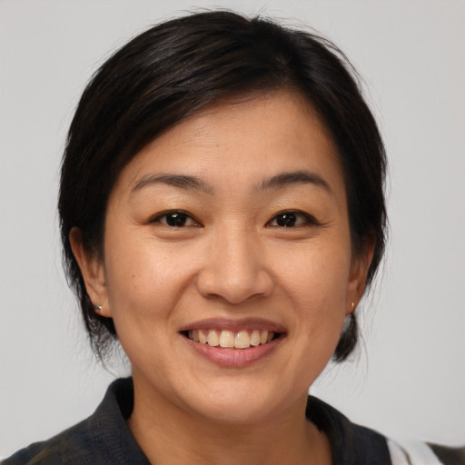 Joyful asian adult female with medium  brown hair and brown eyes