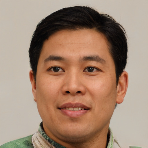 Joyful asian adult male with short  brown hair and brown eyes
