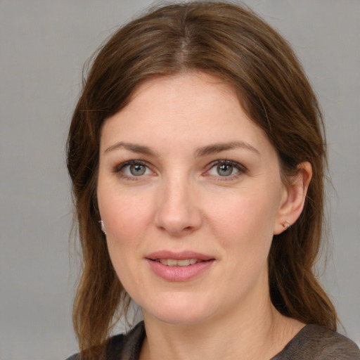 Joyful white young-adult female with medium  brown hair and grey eyes