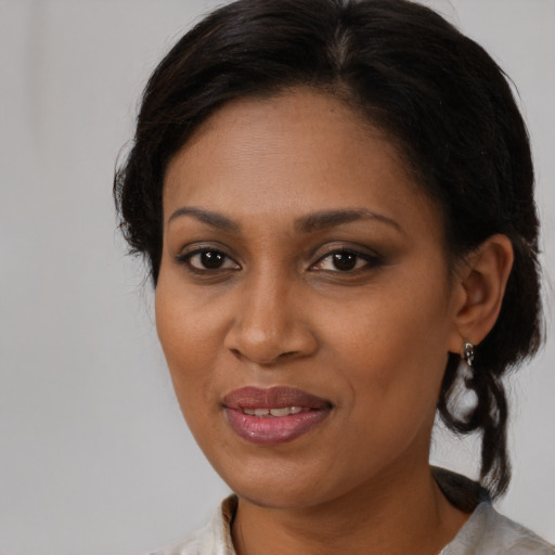 Joyful black young-adult female with medium  brown hair and brown eyes