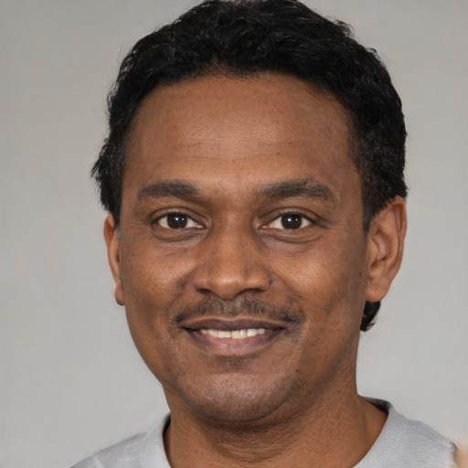 Joyful latino adult male with short  black hair and brown eyes