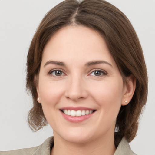 Joyful white young-adult female with medium  brown hair and green eyes