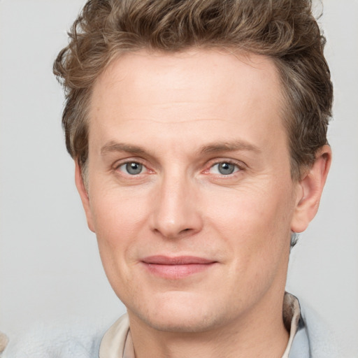 Joyful white adult male with short  brown hair and grey eyes