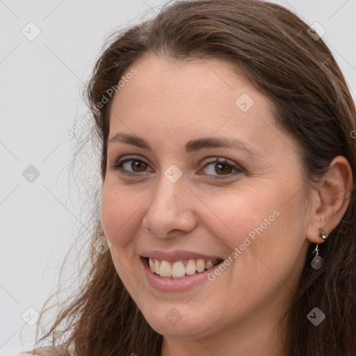 Joyful white young-adult female with long  brown hair and grey eyes