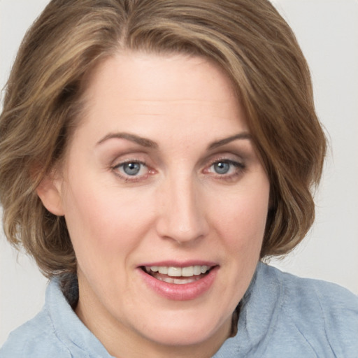 Joyful white young-adult female with medium  brown hair and blue eyes