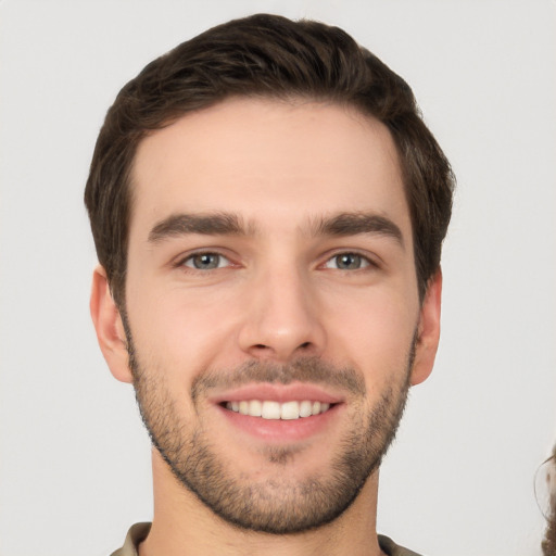 Joyful white young-adult male with short  brown hair and brown eyes