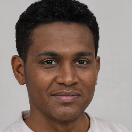 Joyful black young-adult male with short  brown hair and brown eyes