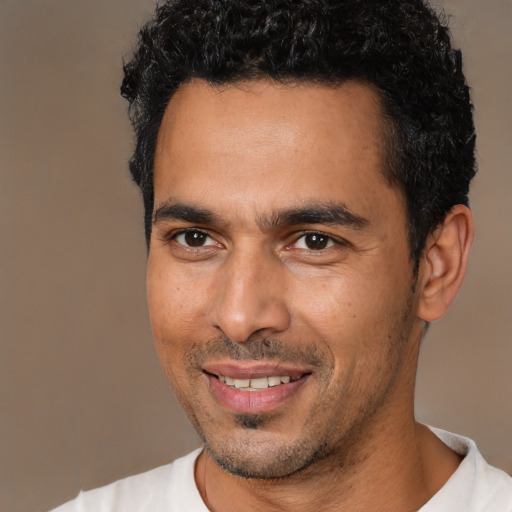 Joyful white young-adult male with short  black hair and brown eyes