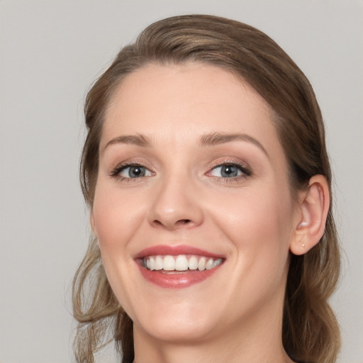 Joyful white young-adult female with medium  brown hair and blue eyes