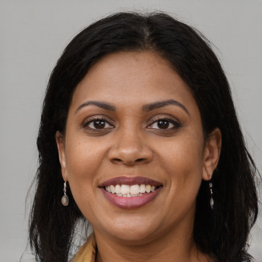 Joyful black young-adult female with long  brown hair and brown eyes