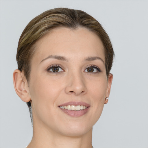 Joyful white young-adult female with medium  brown hair and grey eyes