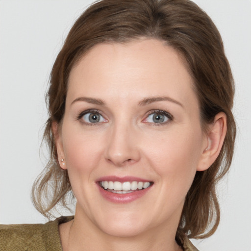 Joyful white young-adult female with medium  brown hair and grey eyes