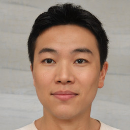 Joyful asian young-adult male with short  black hair and brown eyes