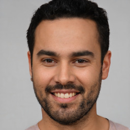 Joyful white young-adult male with short  black hair and brown eyes