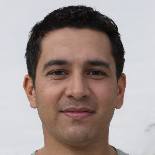 Joyful white young-adult male with short  black hair and brown eyes