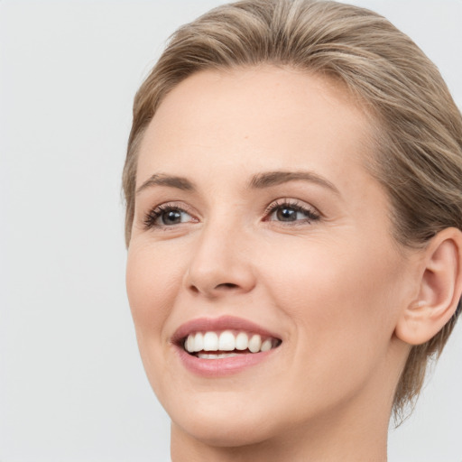 Joyful white young-adult female with medium  brown hair and blue eyes