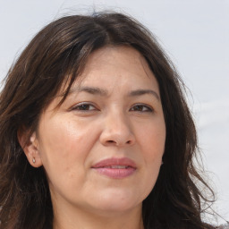 Joyful white adult female with long  brown hair and brown eyes