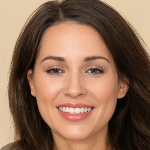 Joyful white young-adult female with long  brown hair and brown eyes