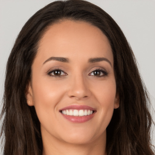 Joyful white young-adult female with long  brown hair and brown eyes