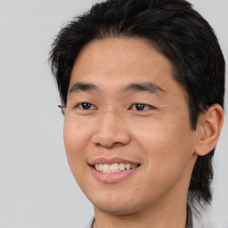 Joyful asian young-adult male with short  brown hair and brown eyes