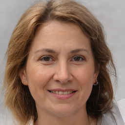 Joyful white adult female with medium  brown hair and brown eyes