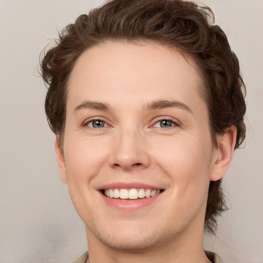 Joyful white young-adult female with short  brown hair and green eyes