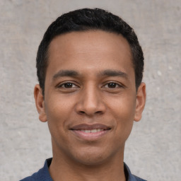 Joyful latino young-adult male with short  black hair and brown eyes