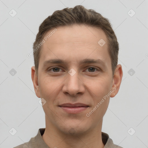 Joyful white young-adult male with short  brown hair and grey eyes