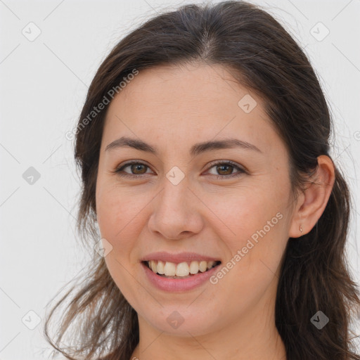 Joyful white young-adult female with long  brown hair and brown eyes