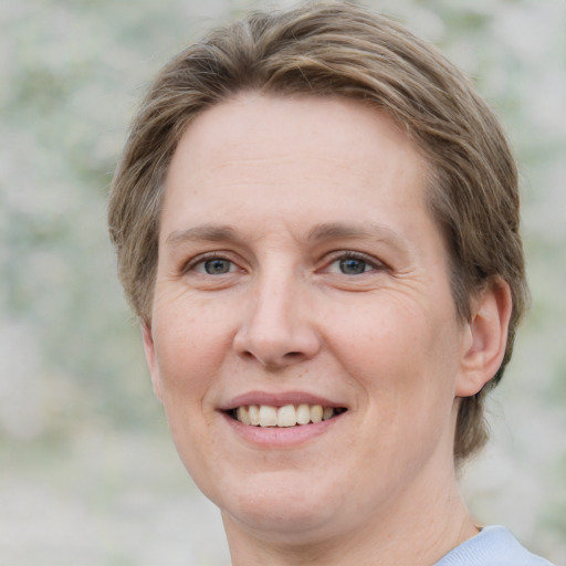 Joyful white adult female with medium  brown hair and green eyes