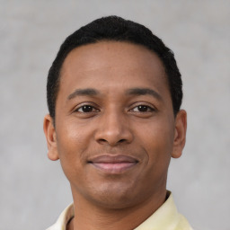 Joyful latino young-adult male with short  brown hair and brown eyes