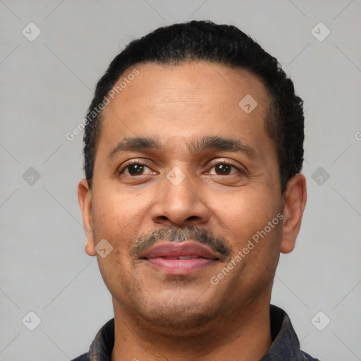 Joyful latino adult male with short  black hair and brown eyes