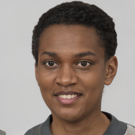 Joyful black young-adult female with short  black hair and brown eyes