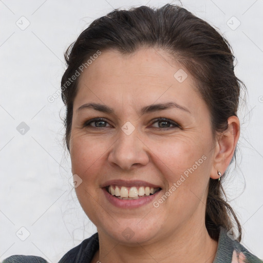 Joyful white adult female with medium  brown hair and brown eyes