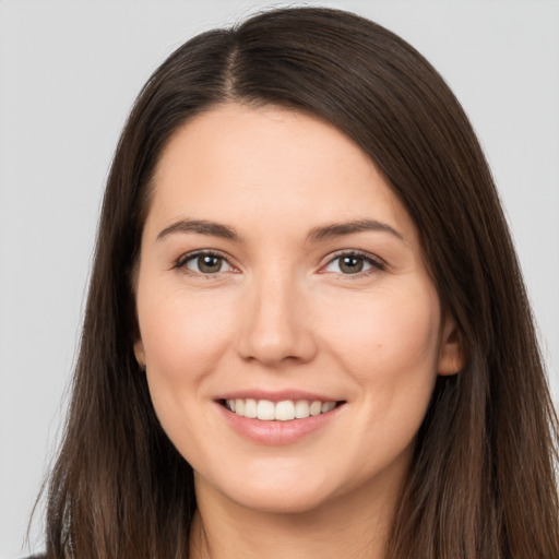 Joyful white young-adult female with long  brown hair and brown eyes