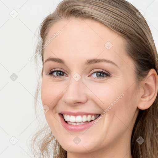 Joyful white young-adult female with long  brown hair and blue eyes