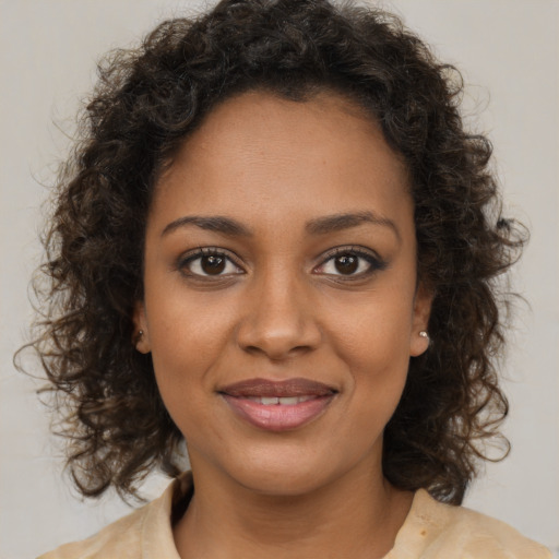 Joyful black young-adult female with medium  brown hair and brown eyes