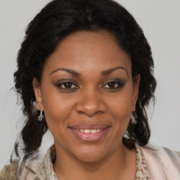 Joyful black adult female with medium  brown hair and brown eyes