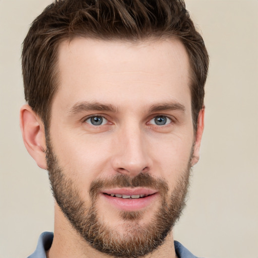 Joyful white young-adult male with short  brown hair and grey eyes