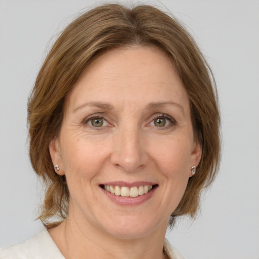 Joyful white adult female with medium  brown hair and green eyes