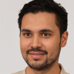 Joyful latino young-adult male with short  brown hair and brown eyes