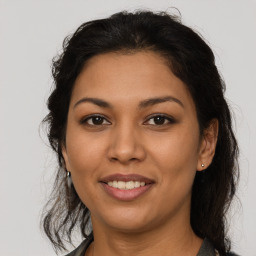 Joyful latino young-adult female with medium  brown hair and brown eyes