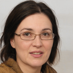 Joyful white adult female with medium  brown hair and grey eyes