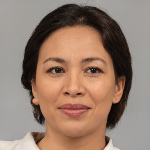 Joyful asian adult female with medium  brown hair and brown eyes