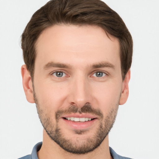 Joyful white young-adult male with short  brown hair and grey eyes