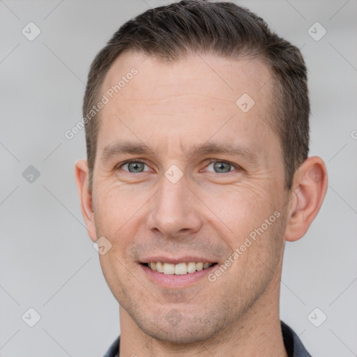 Joyful white adult male with short  brown hair and grey eyes